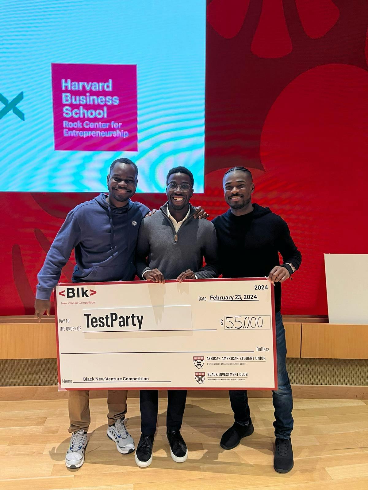 Michael holding award check from HBS Black Venture Competition.